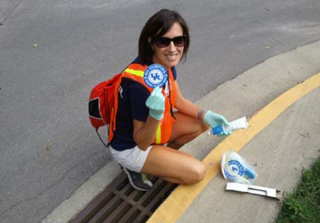 A participant prepares to install a medallion to a storm drain.